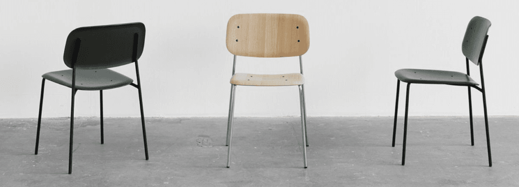 Три стільці Soft Edge 40: два темно-сірого кольору зі сталевими ніжками, один зі світлого дерева зі сріблястими ніжками.