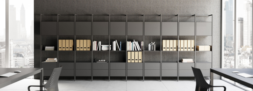 AUTO-DRAFT: Gray modular bookshelf with drawers and open shelves holding books and files. Office furniture, seen at an angle.
