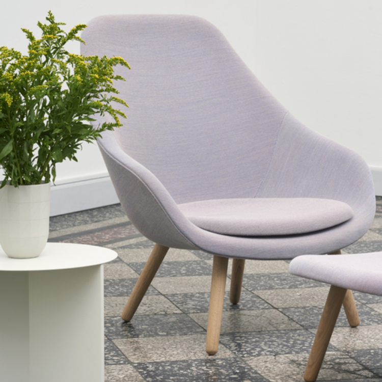 AAL 93 high-back lounge chair in soft light purple upholstery with a curved oak frame and matching footstool.