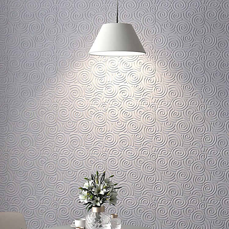 Close-up of Auspice Cloud grey PET felt wall tiles featuring a soft, sculptural spiral pattern under warm pendant light.