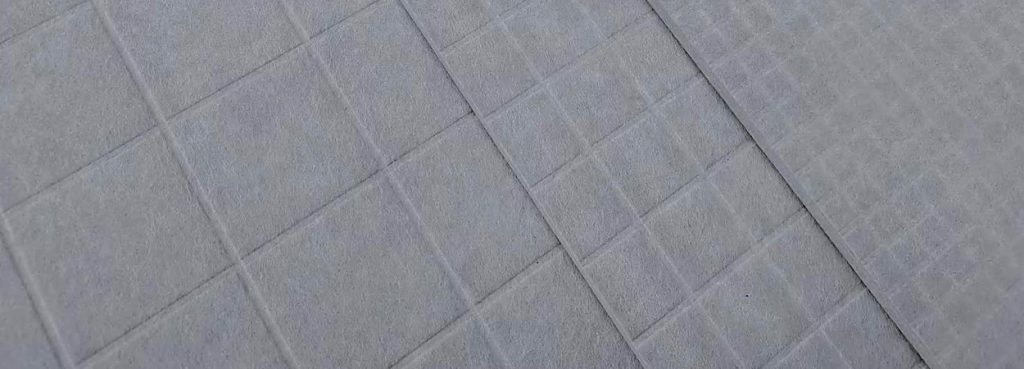 Close-up of a grey Grid Acoustic Panel made of textured PET felt with a precise square-grid embossed pattern.