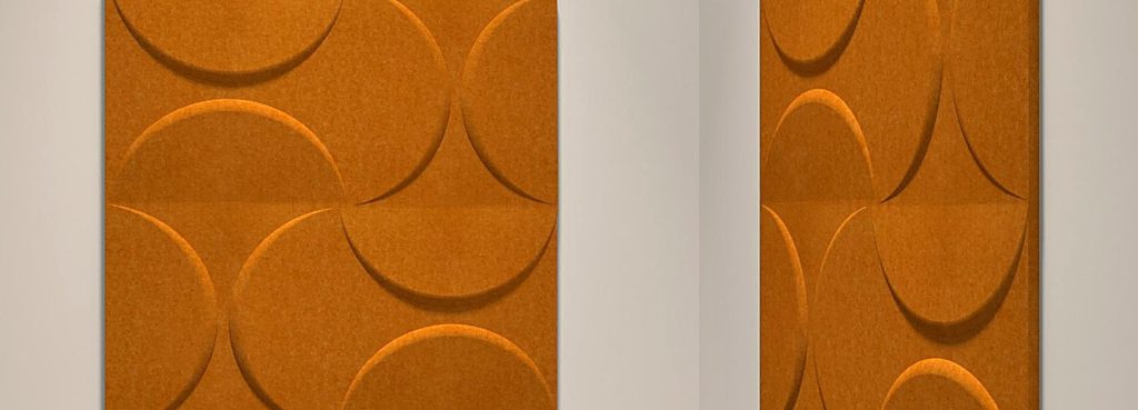 Lunar Crescent Big acoustic wall panels in warm orange PET felt with embossed circle and crescent geometric patterns.