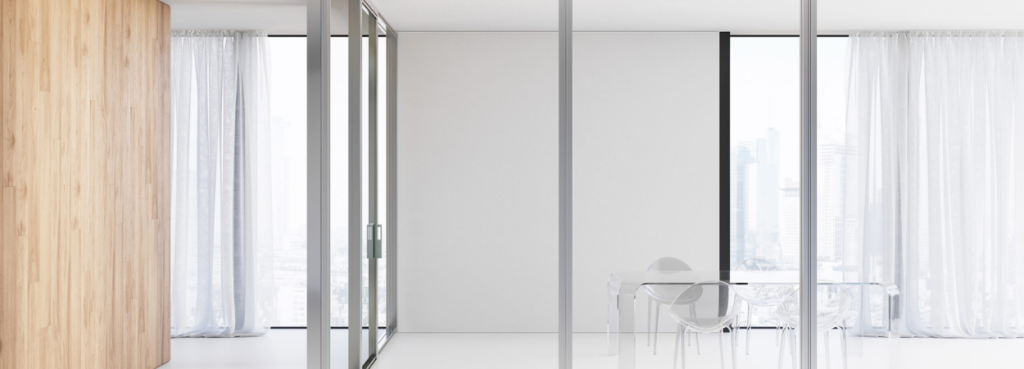 Over modular wall partition featuring light wood panels combined with clear glass and a structural silver frame.