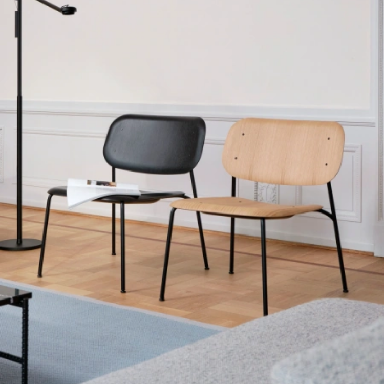 Two Soft Edge 100 lounge chairs with organic plywood shells and sleek black steel bases in a modern interior setting.
