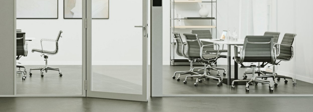 Ultra Silence System glass door partition installed in a modern office, featuring a hinged design and metallic frame.