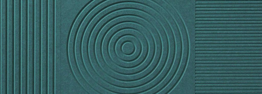 V-Flute Carved Acoustic Panel in dark teal PET felt featuring geometric patterns of lines and concentric circles.