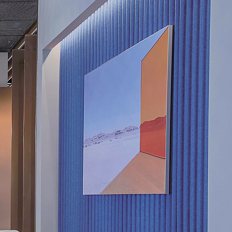 Blue Wave-Patterned Acoustic Panel wall covering with a modern desert landscape art piece mounted on top.